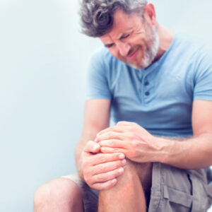Man with knee pain close up. Pain relief concept